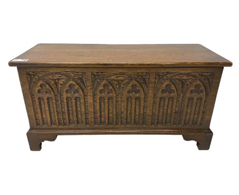 Mid-20th century oak blanket box, hinged lid over front carved with Gothic tracery work and flower heads, on bracket feetDime