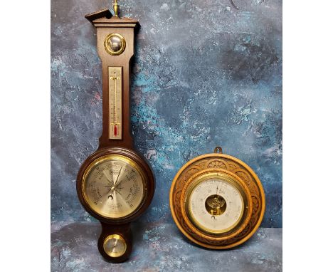 An early 20th century oak barometer, carved with demi-flowers, 23cm diam;&nbsp; another, wheel barometer, Comitti of London (