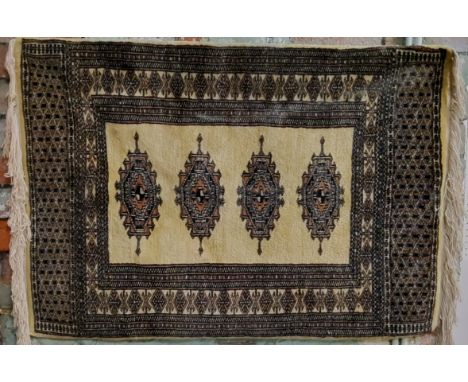 A Pakistani Bokhara rug in vivid tones of gold, black and light brown 