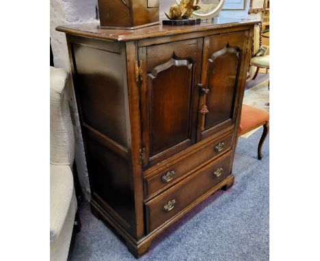 Attributed to Titchmarsh and Goodwin, English oak television cabinet, two arched panel doors revealing niche, above two long 