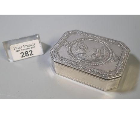 White metal octagonal snuff box, the top depicting figures in a garden setting, the interior with German text and dated Janne