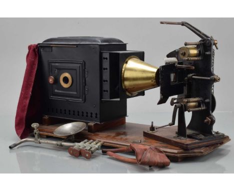 A Magic Lantern, tin and brass, with 35mm film strip mechanism on turning plate, rack n pinion focusing lens, glass illuminan