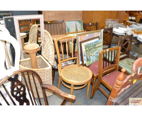 An Ercol stick back chair together with a cane seated dining chair; a mirror; a brass rubbing and a stool