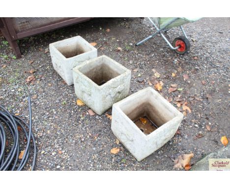 Three concrete garden planters decorated with horses 