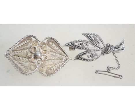 Two silver filigree fret pierced brooches one being of leaf form, the other having a flower with ball finial to centre. Both 