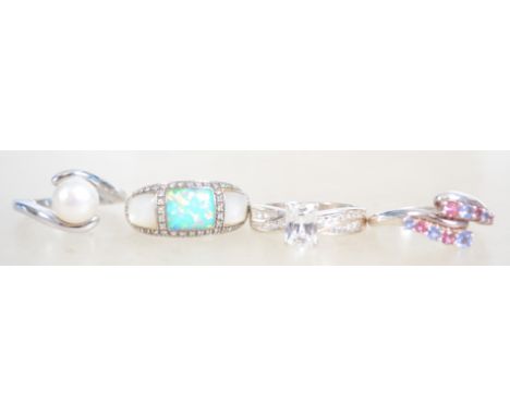 A group of 4 ladies dress rings one being set with mother of pearl and opal, one being a crossover ring with pink and blue CZ