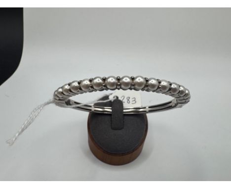 A silver bangle set with simulated pearls 23 gms