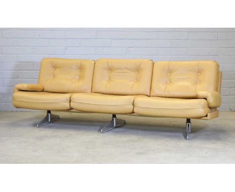 A mustard yellow leather three-seater settee,1970s, with button backs and seat cushions, raised on chrome strut supports, 244