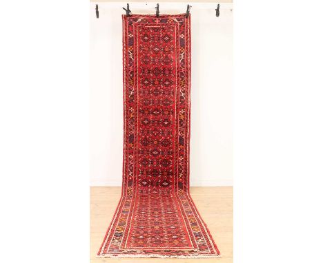 A North West Persian Malayer Runner,20th century, repeating to motifs to a red ground within a multi-border,485 x 91cmConditi