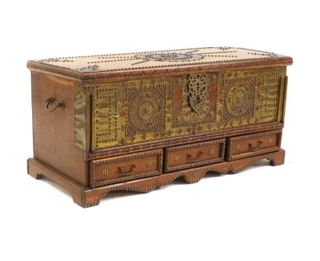 A hardwood and brass studded Zanzibar chest,late 19th to early 20th century, with applied brass work, complete with three dra