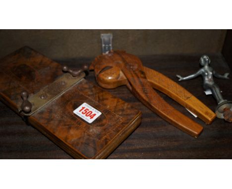 A Scandinavian carved wood nutcracker; together with a vintage chrome nude car mascot; and a vintage tie press. 