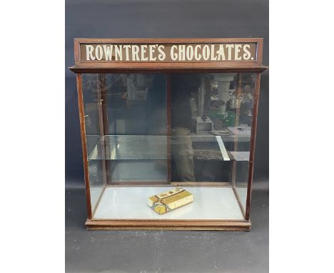 A mahogany shop counter rear opening dispensing cabinet with single glass shelf, and Rowntree's Chocolates glass pediment, 32