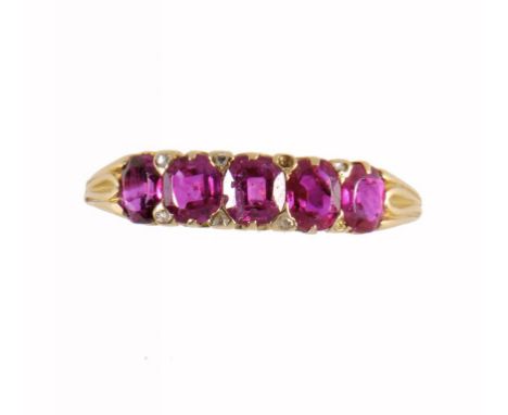 A RUBY RING the five cushion shaped rubies divided by diamond points, in gold, size U ++In good second hand condition, two of