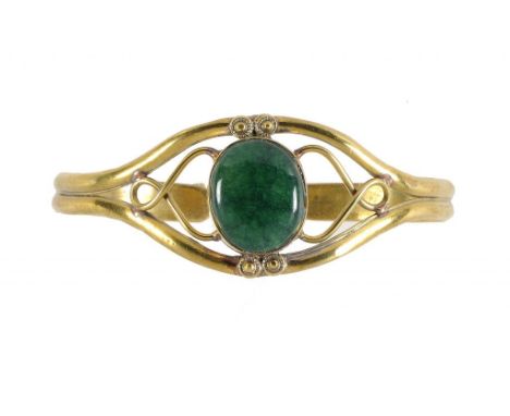 AN ARTS & CRAFTS GILTMETAL AND GREEN STONE SET BANGLE, EARLY 20TH C  ++In satisfactory condition 