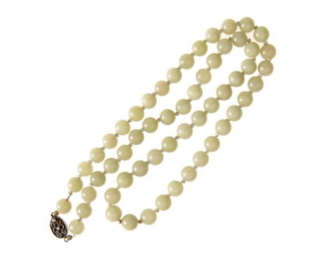 A CHINESE JADE NECKLACE, EARLY 20TH C  of fifty seven 10 and 11mm jade beads, with silver clasp ++In good condition