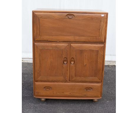 Ercol: A mid 20th century drop-front bureau desk on casters, with central doors, two draws under and drop down compartment to