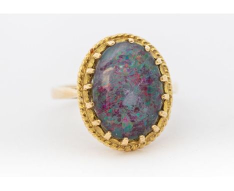 A 9ct gold opal triplet set ring, comprising an oval opal triplet, approx 13 x 9mm claw set within a roped border, size M, to