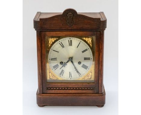 A wooden mantle clock, with brass details
