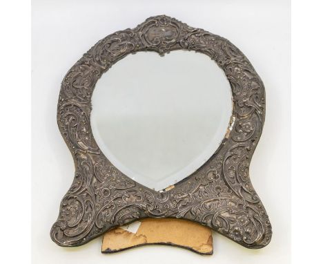 An Edwardian heart shaped silver mounted dressing table mirror, the repousse silver border decorated with foliage and scrollw