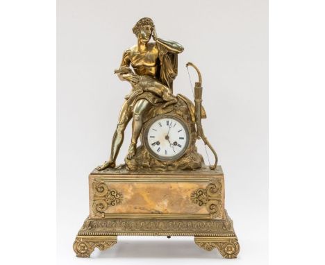 A French mantel clock depicting in brass a mythical hunter with a long bow seated on a rock and a deer. Raised on a white/cre