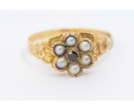 A Victorian pearl and garnet set gold ring, comprising a flower cluster set to the centre with a small garnet within a border