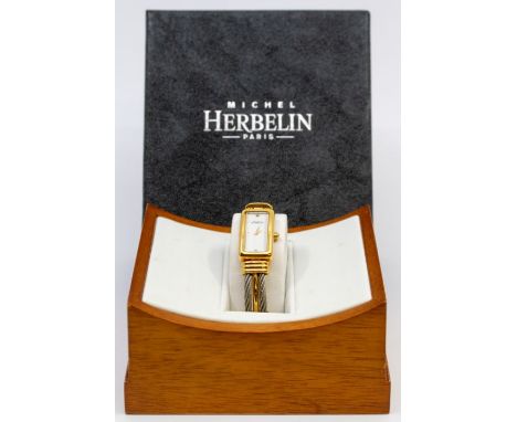 A ladies steel and gold plated wristwatch by  Michel Herbelin, comprising a rectangular signed white dial with gilt indices, 