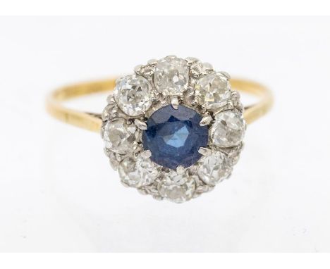 An Edwardian sapphire and diamond 18ct gold cluster ring, comprising a central round mixed cut sapphire approx 6mm, within a 