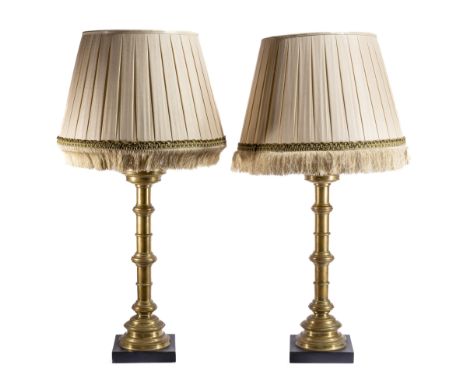 A PAIR OF BRASS LARGE 'ALTAR CANDLESTICK' LAMPS, 20TH CENTURY on square ebonised bases, the circular brass sticks with reeded