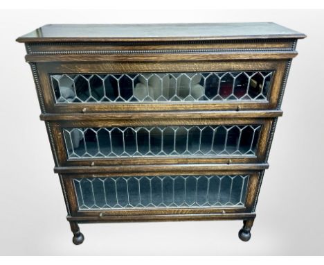 An Edwardian oak and leaded glass three tier stacking bookcase in the style of Globe-Wernicke, 115 cm x 33 cm x 129 cm  