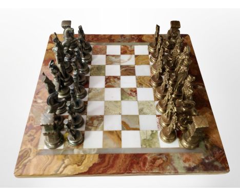 An onyx chessboard and set of cast metal chess pieces.