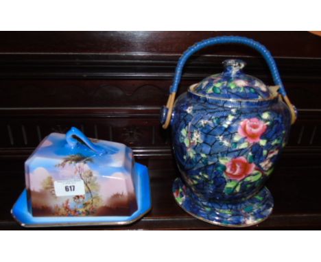 A Ceramic Biscuit Barrel with lid on matching base, deep pink rose decoration on blue ground and A Sylvac Butter Dish.