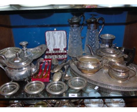 A Shelf of Sliver Plated Items to include a tea service on tray, two claret jugs, wine coasters etc. €60-80