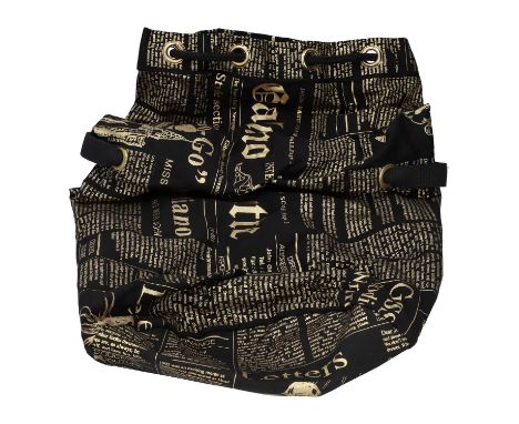 JOHN GALLIANO Reisetasche "GAZETTE". Schwarzes Modell aus Baumwolle mit goldfarbenen Texten, Ösen mit Strick als Verschluss. 