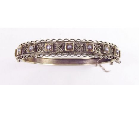 An Edwardian gold bangle with wire work and seed pearl decoration