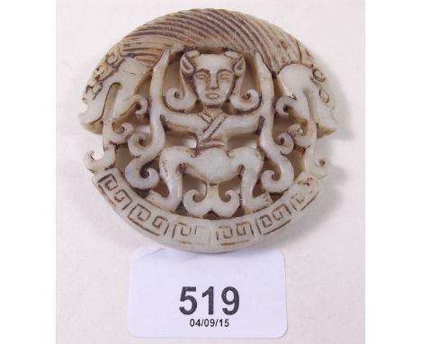 A Chinese carved stone circular plaque with figure and dragons head, 7cm diameter