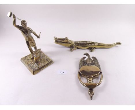 A brass eagle door knocker, brass crocodile and a brass blacksmith