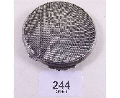 A silver compact with engine turned decoration