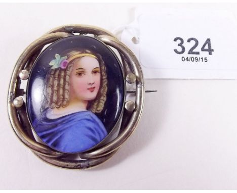 A Victorian painted porcelain brooch depicting young girl in pinchbeck surround