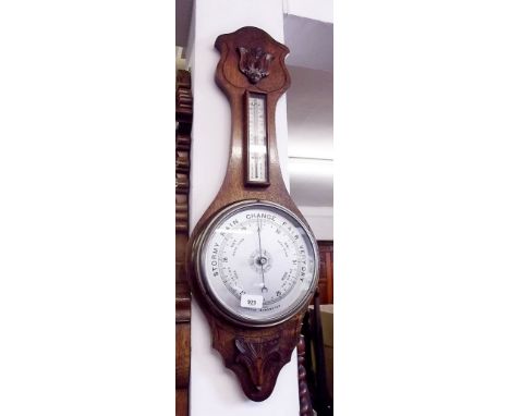 A late Victorian carved oak aneroid barometer/thermometer 