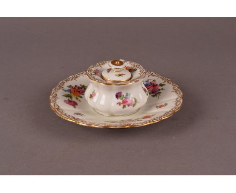 An Edwardian period Dresden porcelain inkwell, the circular base supporting flared rim well, complete with ink liner and lid,