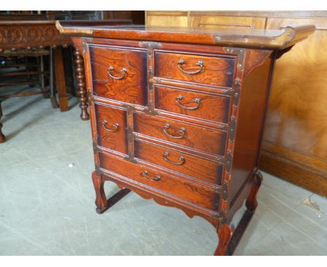 A Chinese alter style table cabinet, in bulls blood finish, with seven drawers on shaped legs 68 cm W 