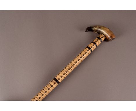 A Vertebrae walking stick, of turned bone and horn construction with steel shaft, horn top and mounted coin pommel and brass 