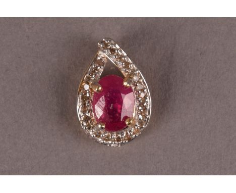 A 14k gold diamond and ruby pendant, the central oval cut ruby, set in a tear drop shaped pendant with small round cut set di