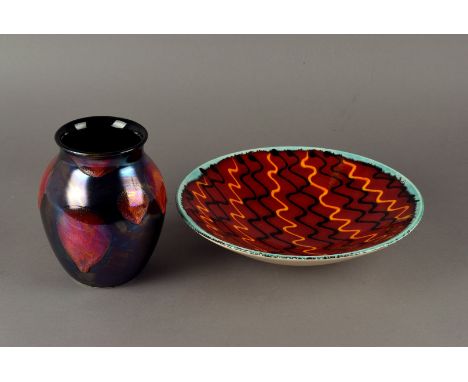 A Poole Studio Pottery Vase, with iridescent red glaze, together with a large red plate with wavy pattern design.(2)  