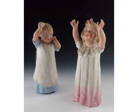 A pair of Gebruder Heubach bisque figures of  young children playing, modelled throwing and catching a ball, 26cm high (2)