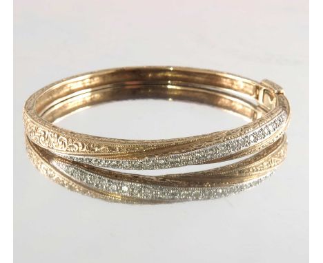 A 9ct gold brilliant-cut diamond hinged bangle, with engraved decoration, estimated total diamond weight 0.40ct, inner diamet