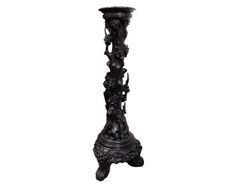 A Chinese carved wood torchiere or jardinière stand, ebonised, carved in relief and pierced as a naturalistic prunus trunk en