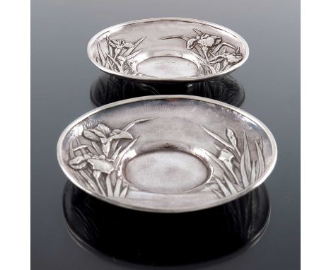 A pair of Japanese silver saucers, Samurai Shokai, Yokohama, embossed with irises in a watery landscape on a planished ground