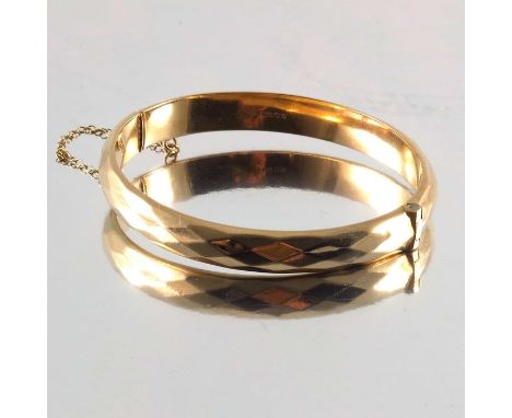 A 9ct gold hinged bangle, of faceted design, hallmarks for London, 1981, inner diameter 5.9cm, 10.1g