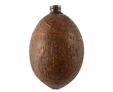 A 19th century carved coconut bugbear flask, with French silver mount,  modelled in relief with a tribal ritual dancing scene